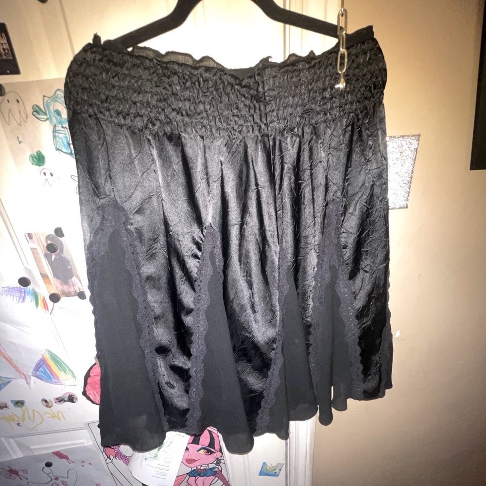 Black satin with lace trim, taffeta panels, flare knee length skirt.